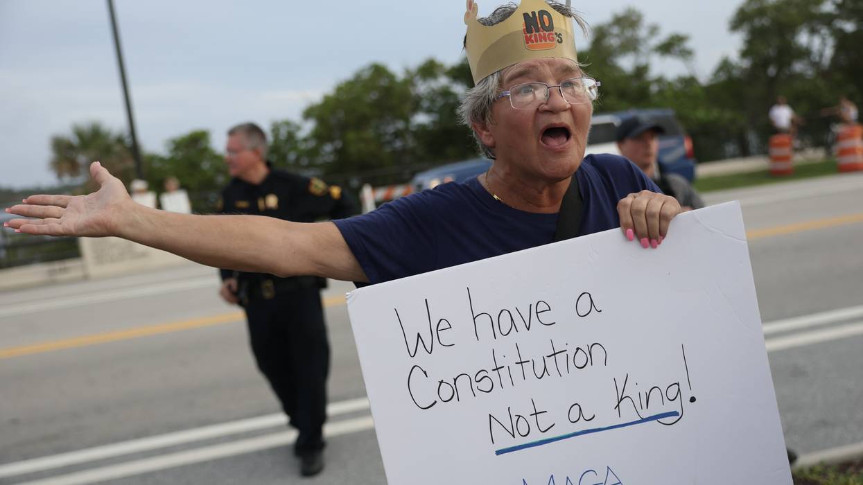 Protester holds sign reading, "We have a Constitution, not a king!"