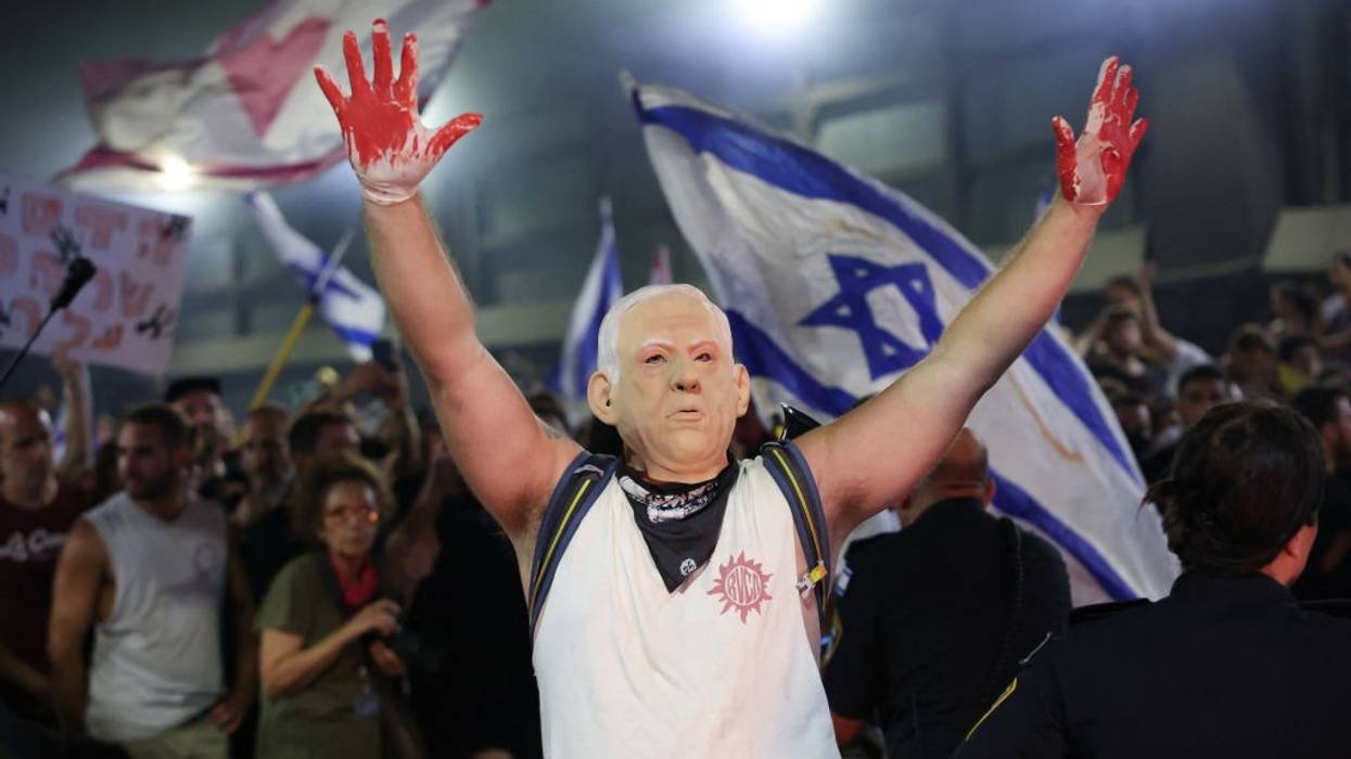 Protester wearing Netanyahu mask with blood-soaked hands