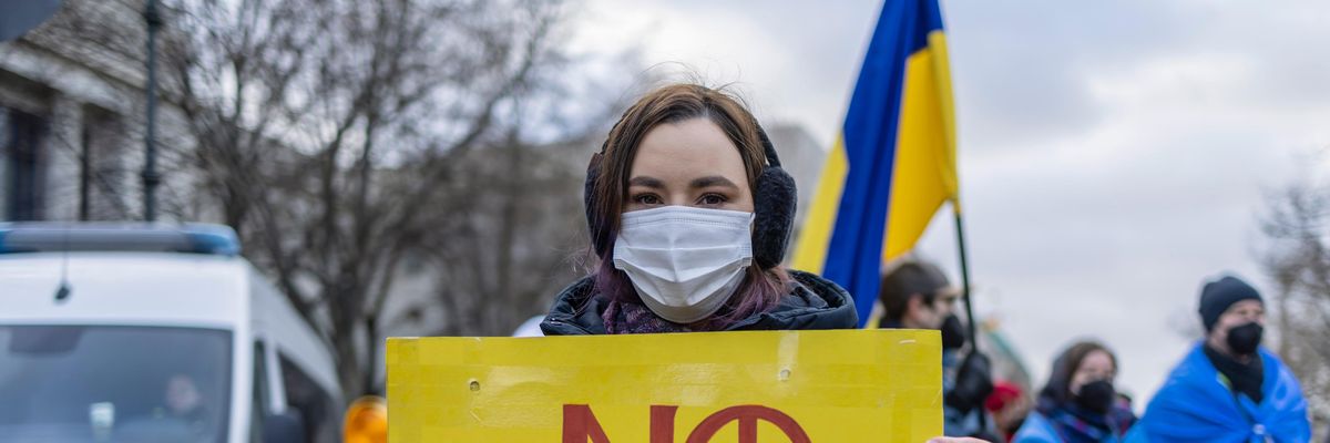 Protester with a sign that says "No War" outside the Russian embassy in Berlin, Germany