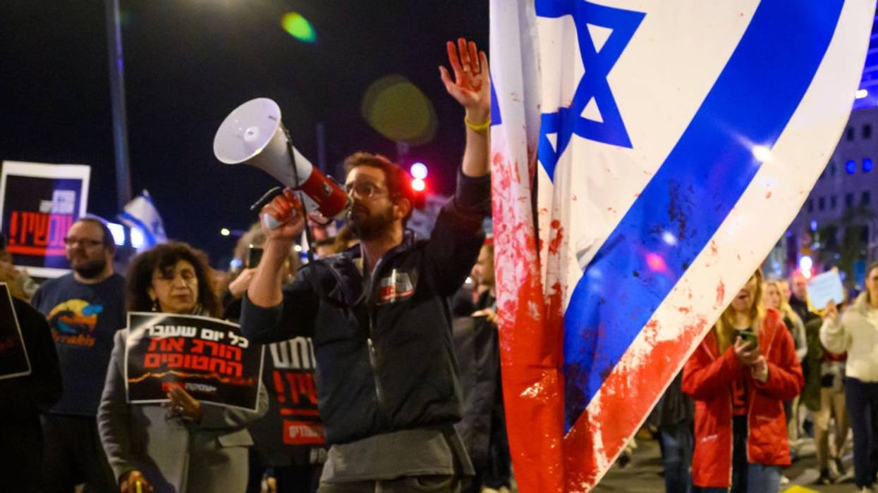 Protester with red paint on his hand marches through the streets.