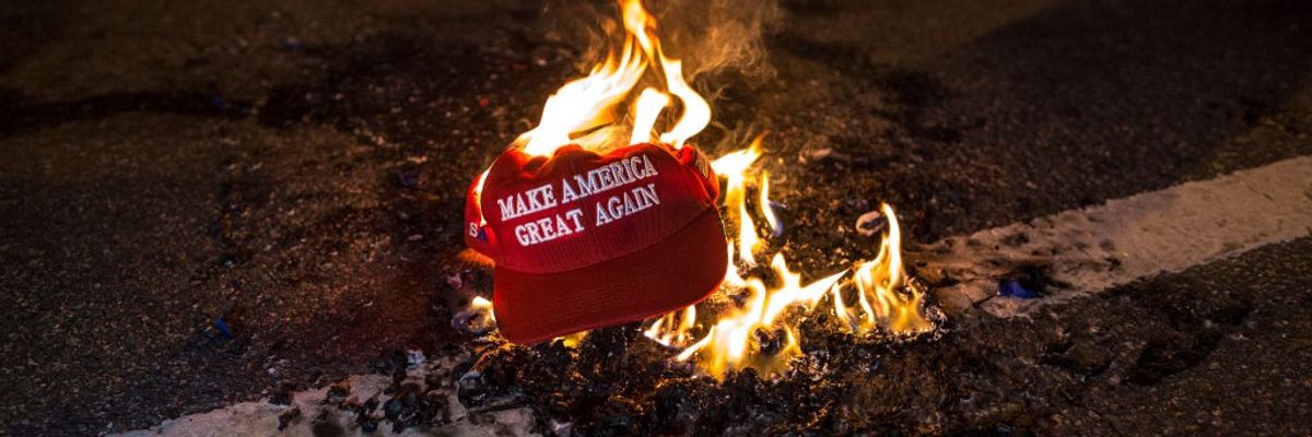 Protesters burn a "Make America Great Again" hat