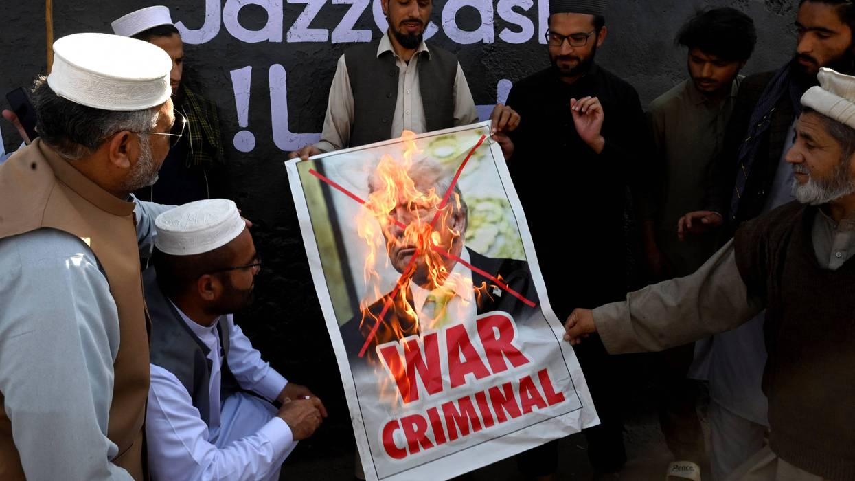 Protesters burn a picture of Trump.
