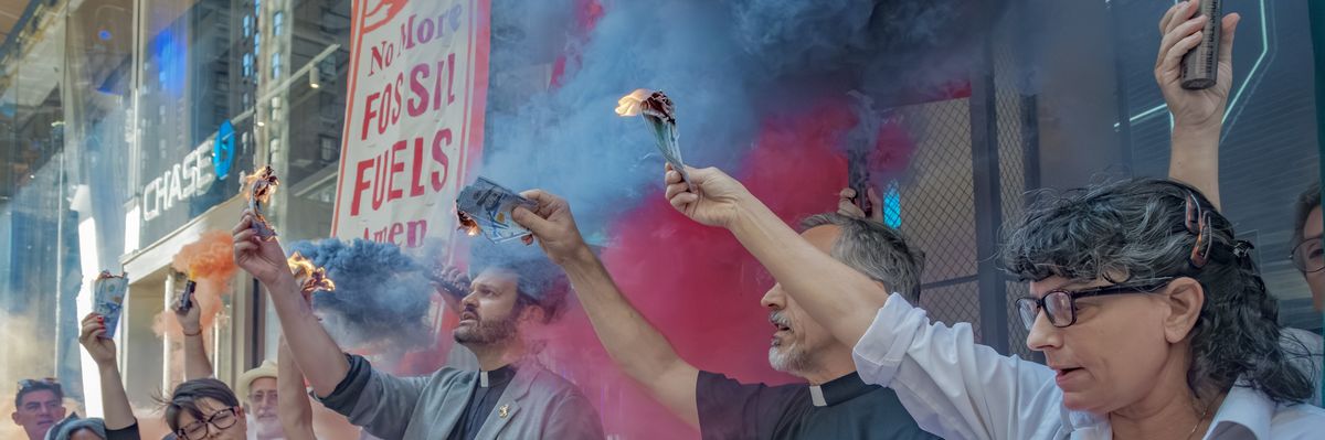 Protesters burn money outside JPMorgan Chase headquarters.