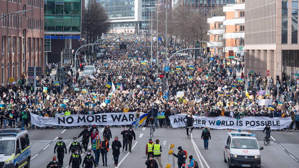Protesters carry "No more war" banner