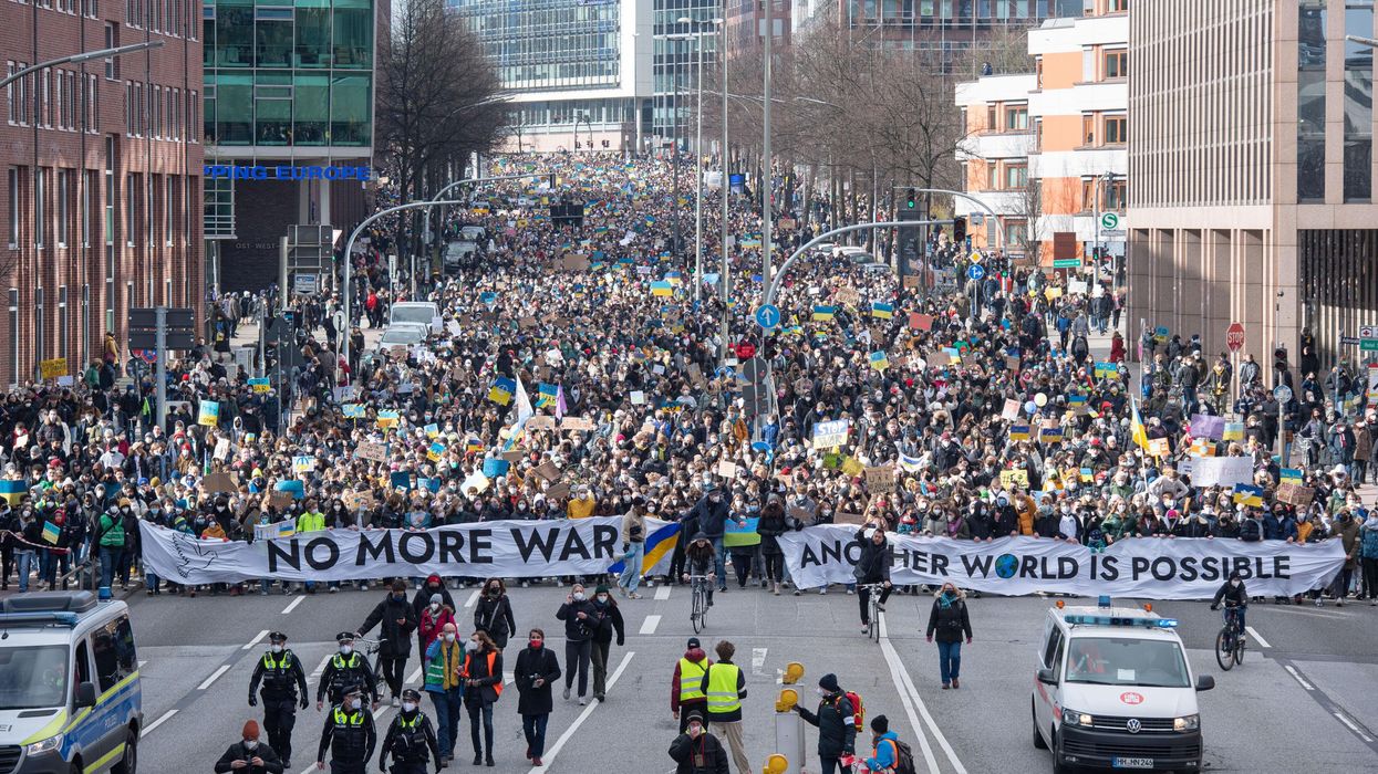 Protesters carry "No more war" banner