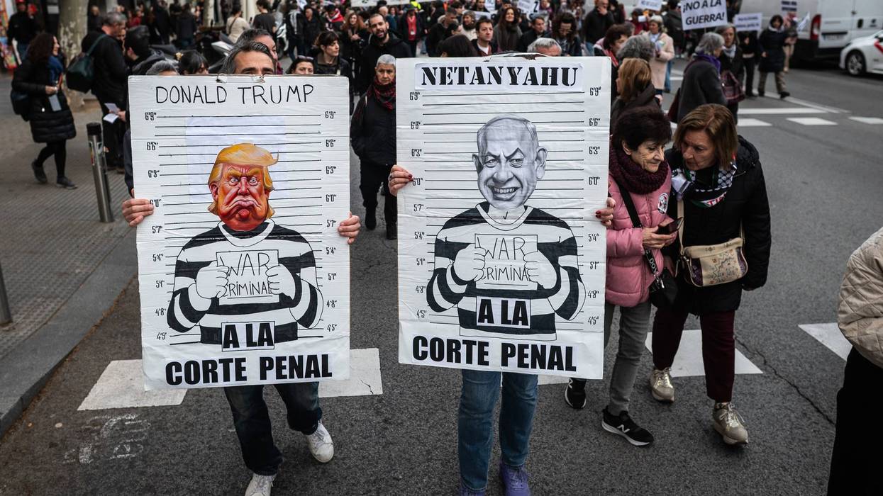 Protesters carry placards with the images of Donald Trump and Benjamin Netanyahu in jail.