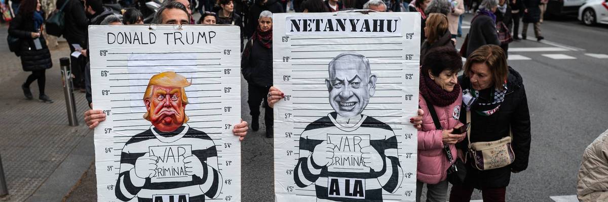 Protesters carry placards with the images of Donald Trump