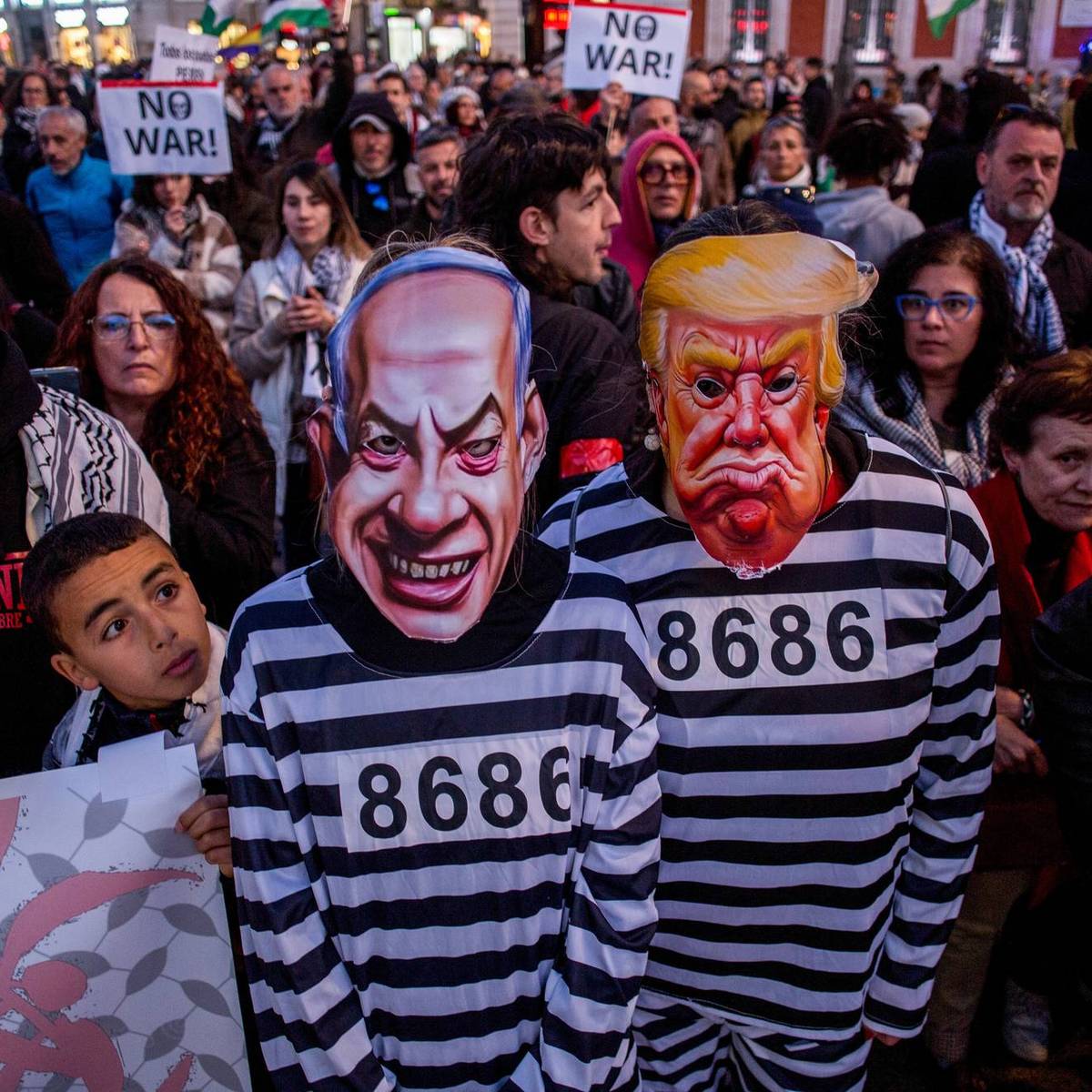 Protesters dressed as prisoners wearing masks of Benjamin