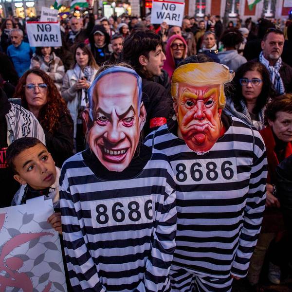 Protesters dressed as prisoners wearing masks of Benjamin