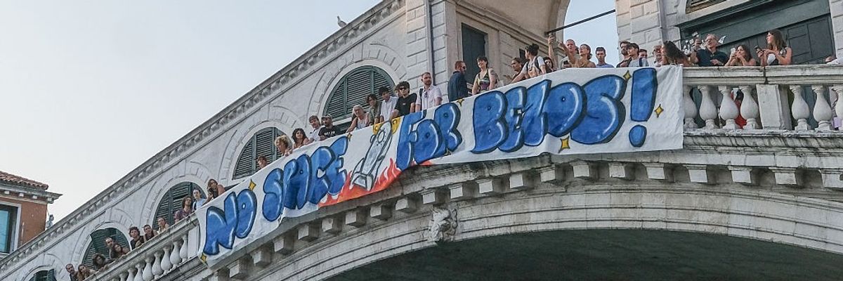 Protesters hang a banner reading "no space for Bezos" from the Rialto Bridge in Venice