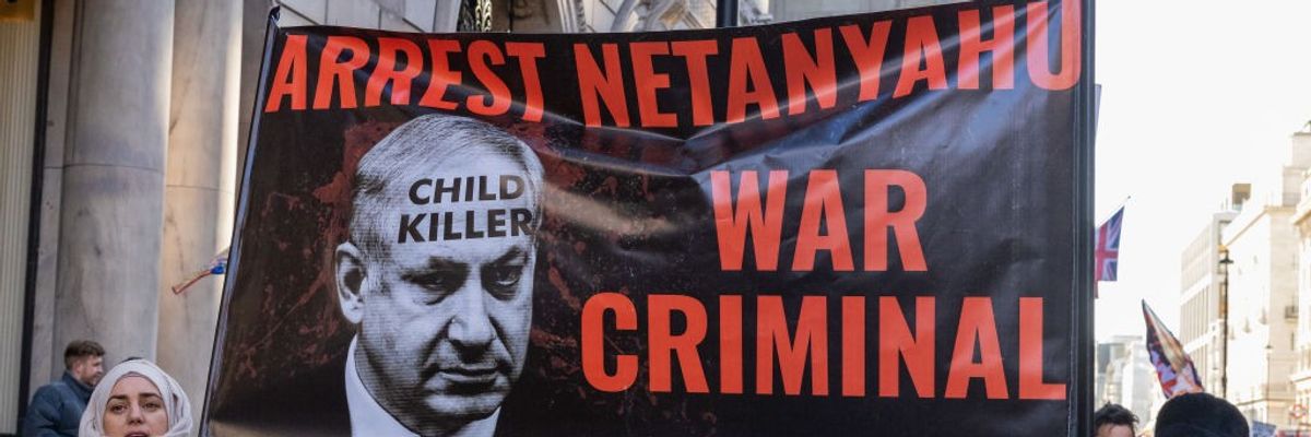 Protesters hold a banner reading "Arrest Netanyahu War Criminal" in London