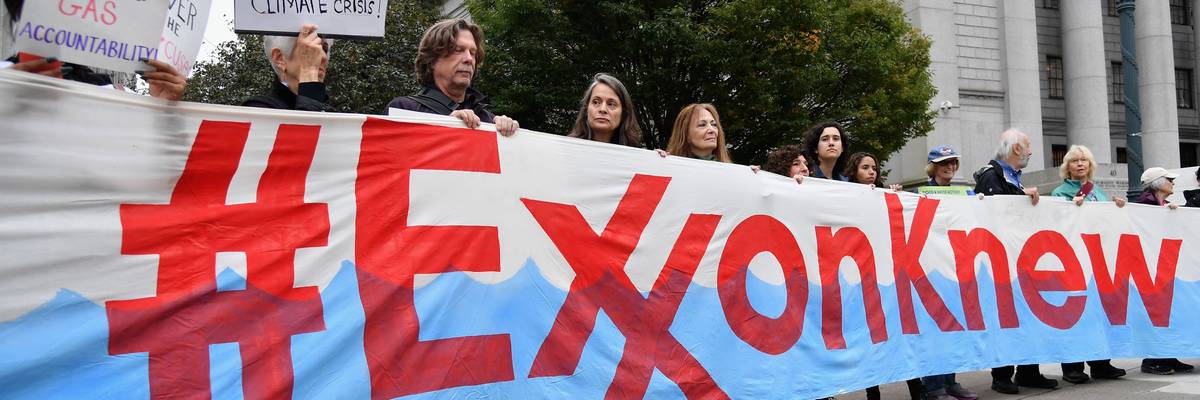 Protesters hold a banner reading, "Exxon knew."