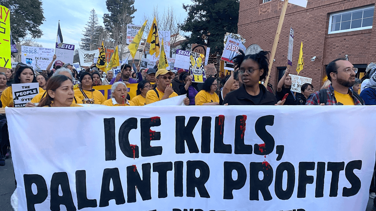 Protesters hold a banner reading "ICE Kills, Palantir Profits"