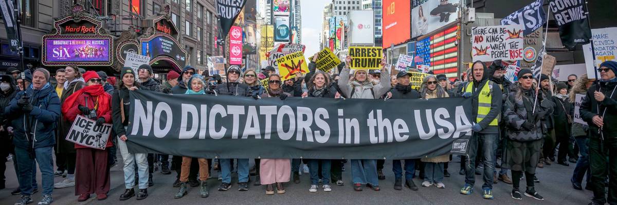 Protesters hold a banner reading "No Dictators in the USA" during a No Kings protest