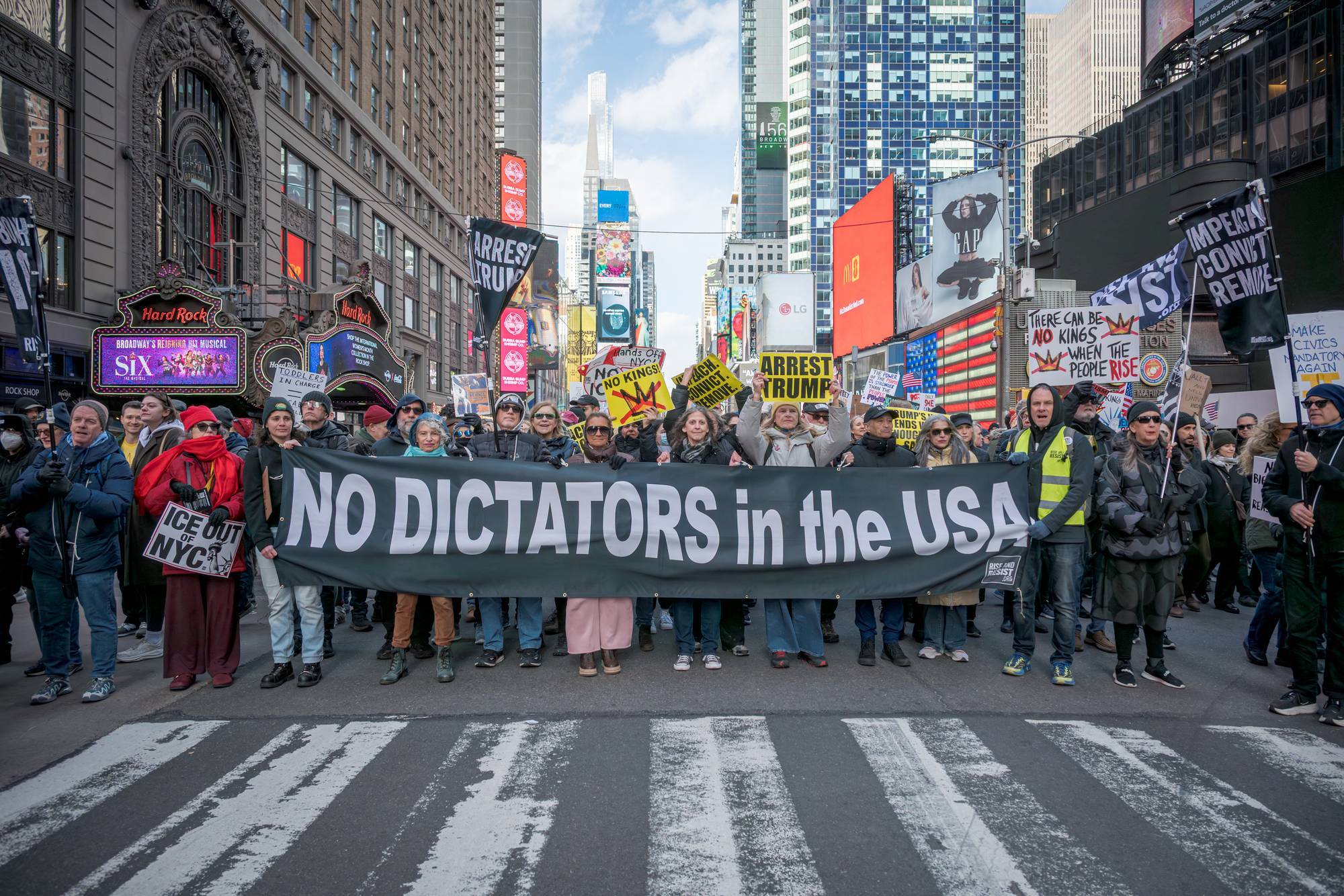 Protesters hold a banner reading "No Dictators in the USA" during a No Kings protest
