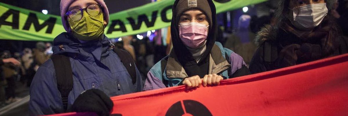 Protesters hold a CO2 banner during a Walk For Future climate march in Warsaw on December 9, 2020.