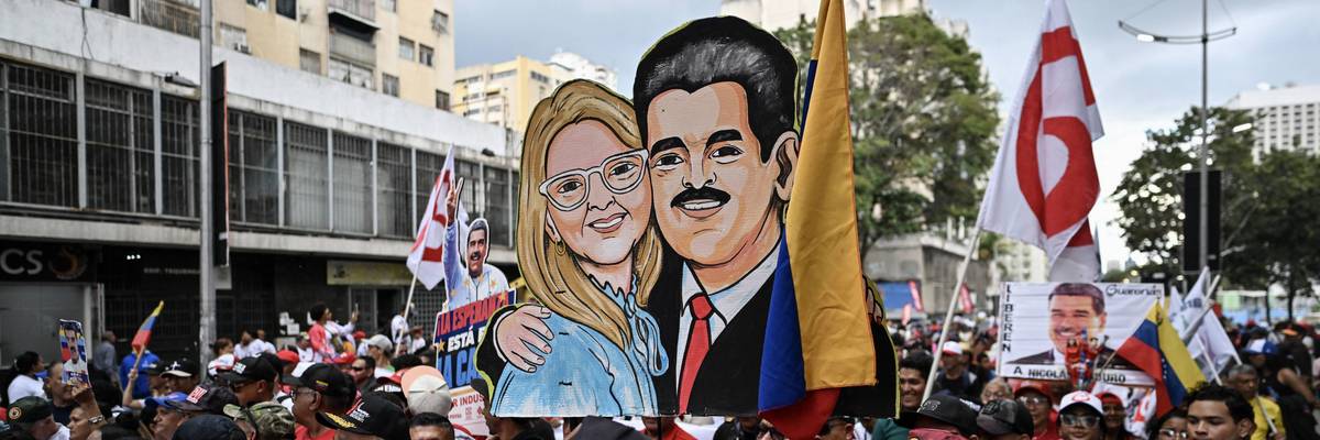 Protesters hold a hand-drawn image of Nicolas Maduro and Cilia Flores.