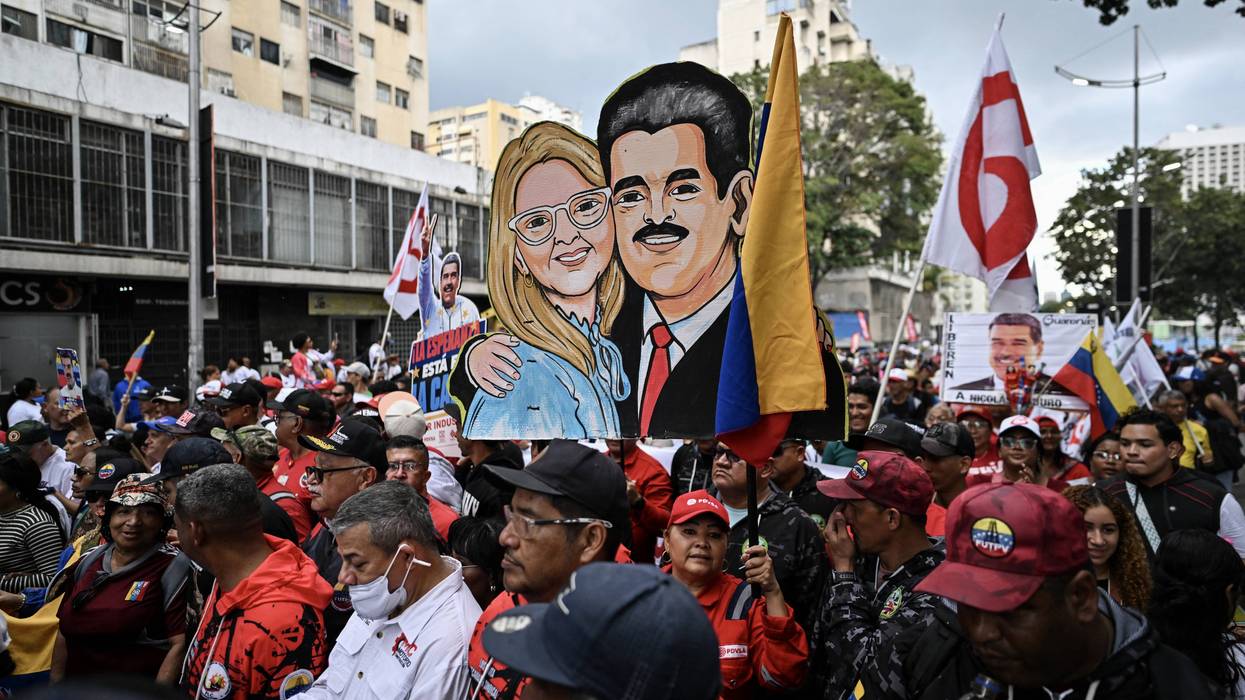 Protesters hold a hand-drawn image of Nicolas Maduro and Cilia Flores.