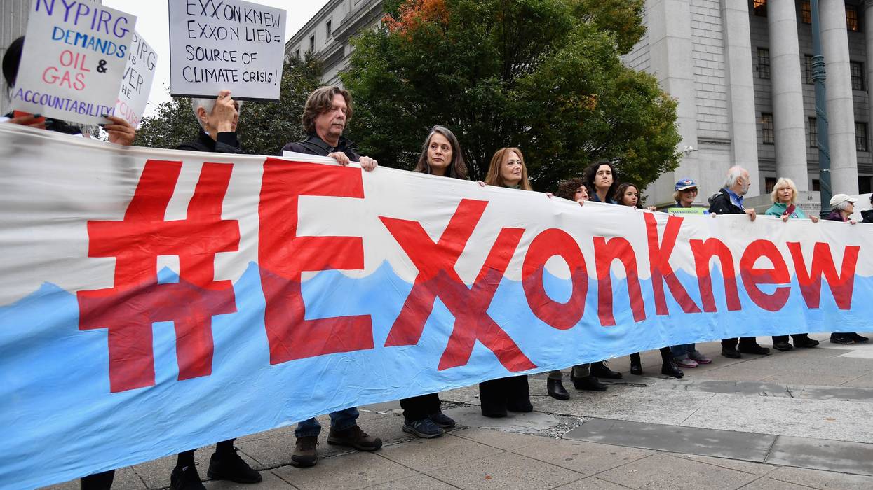Protesters hold Exxon Knew banner.