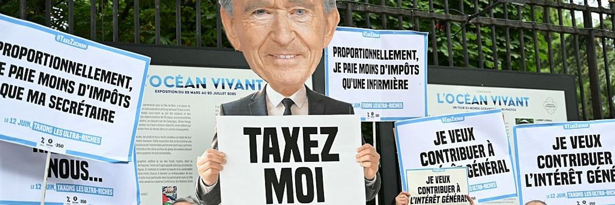 Protesters hold placards outside the French Senate