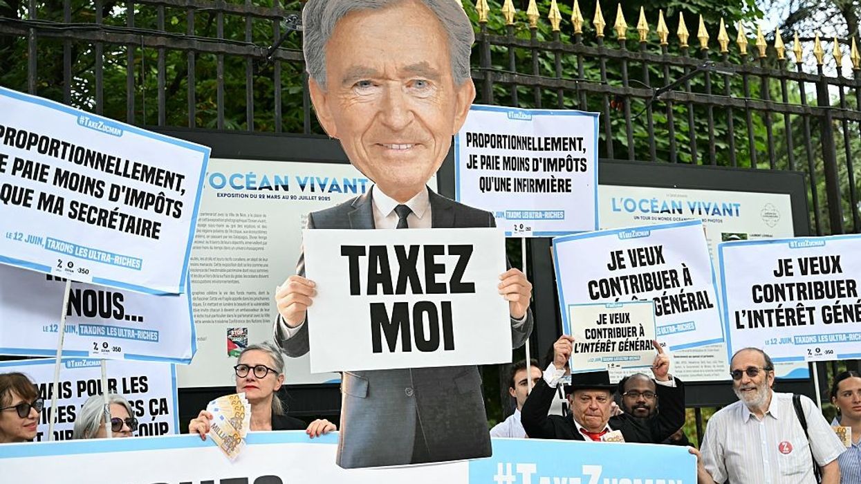 Protesters hold placards outside the French Senate