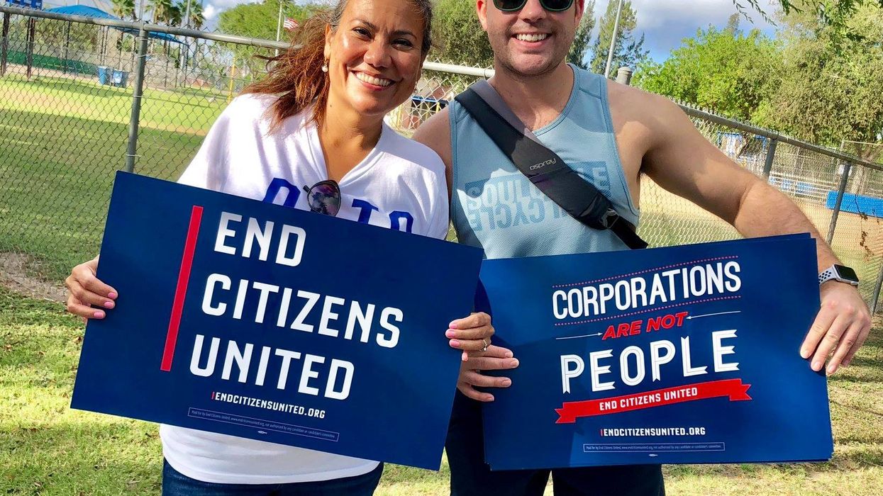 Protesters hold signs calling for an end to Citizens United and corporate personhood