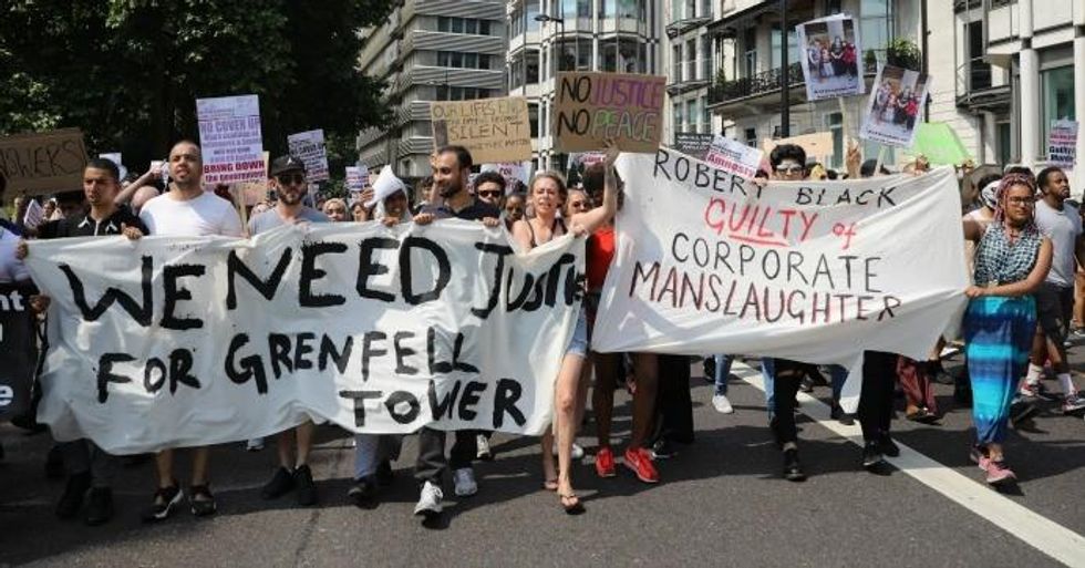 Protesters hold signs calling for justice for the victims of the Grenfell Disaster as they march towards Westminster during an anti-government protest on June 21, 2017 in London, England. A series of protests are held in the capital in response to the Queen's Speech including a 'Day of Rage' organized by the Movement for Justice By Any Means Necessary. The Clement James Centre helping residents of the Grenfell disaster have emphasized that they do not want their grief hijacked for violent means. (Photo: Dan Kitwood/Getty Images)