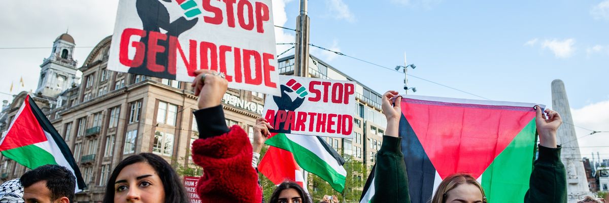 Protesters hold signs denouncing genocide