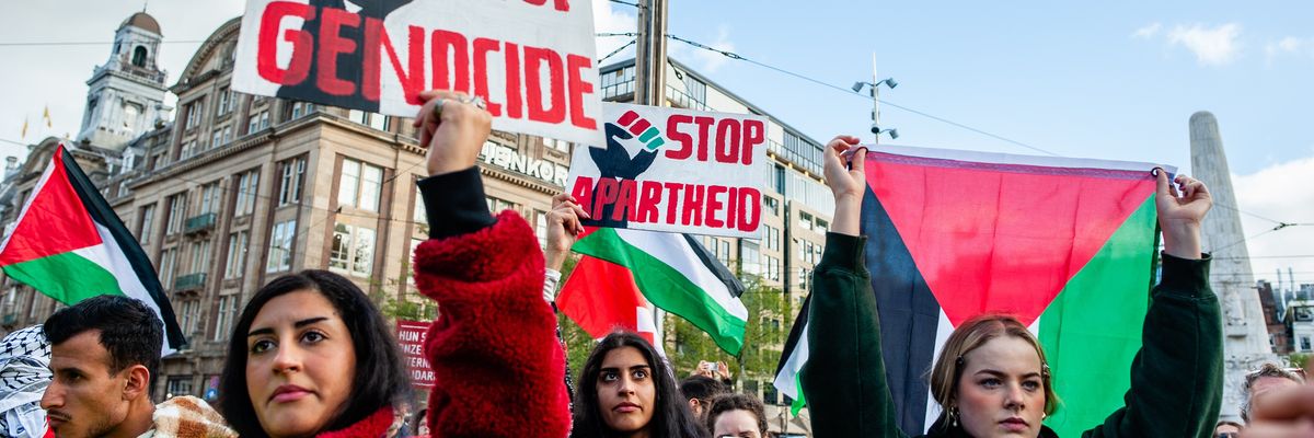 Protesters hold signs denouncing genocide