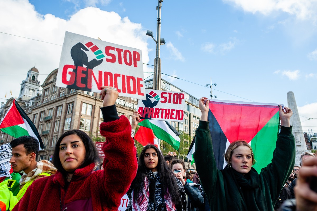 Protesters hold signs denouncing genocide
