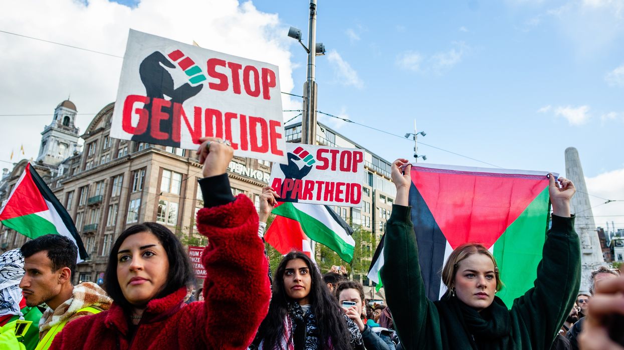 Protesters hold signs denouncing genocide