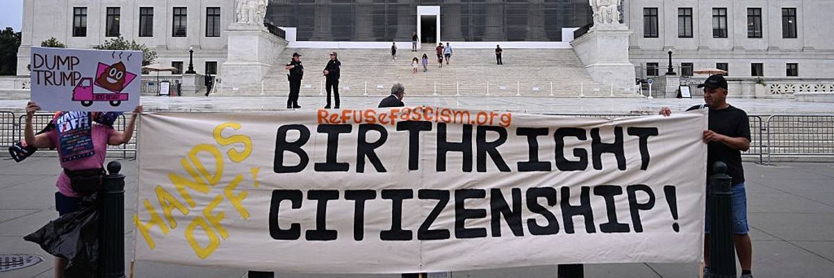 Protesters hold signs reading, "Hands off birthright citizenship" outside the Supreme Court.