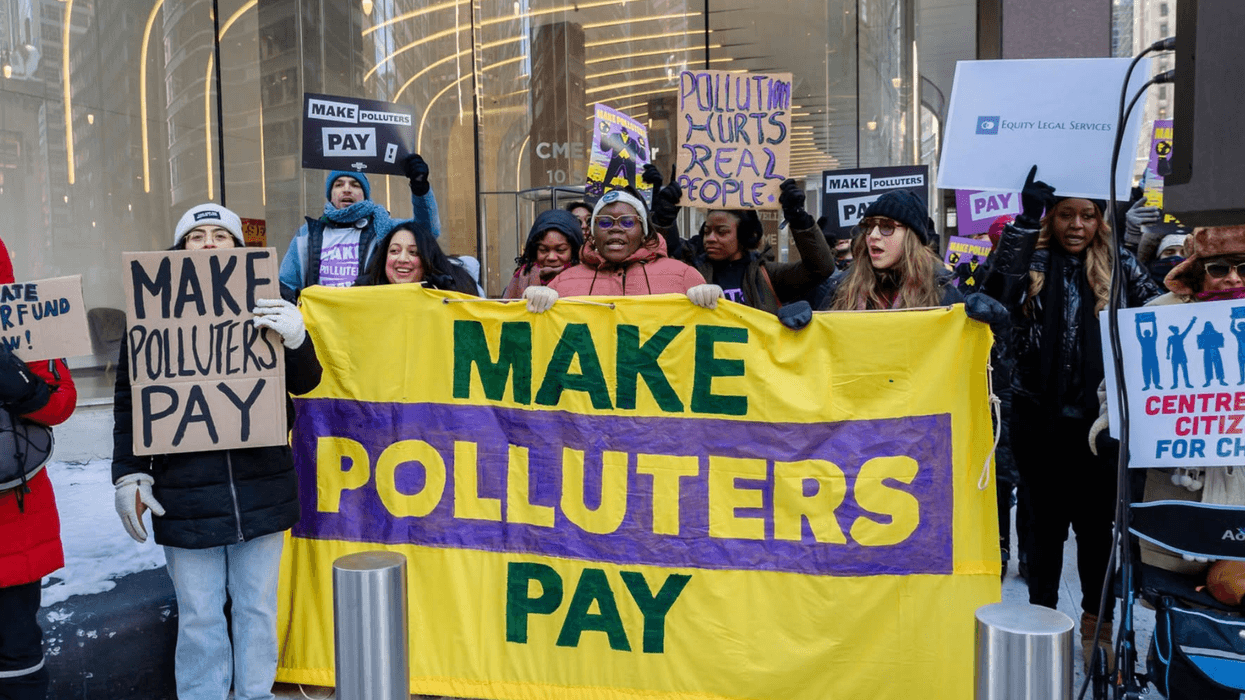 Protesters hold signs reading "make polluters pay"