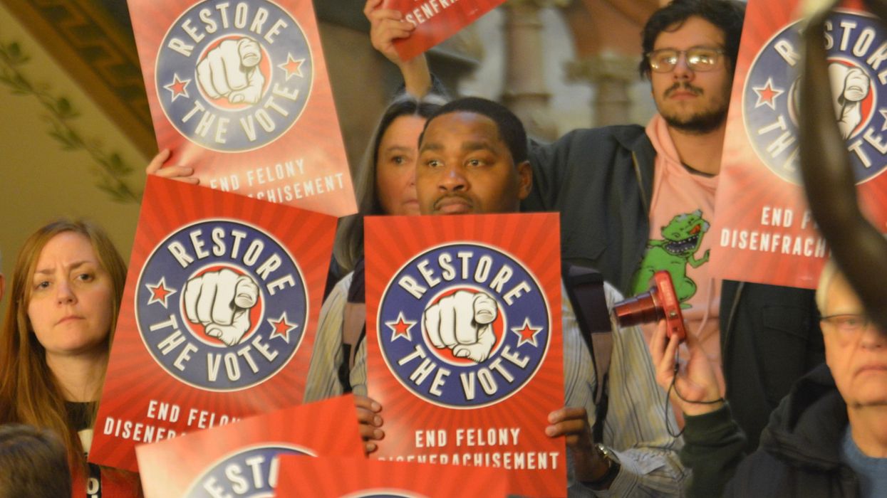 protesters hold signs reading "restore the vote"