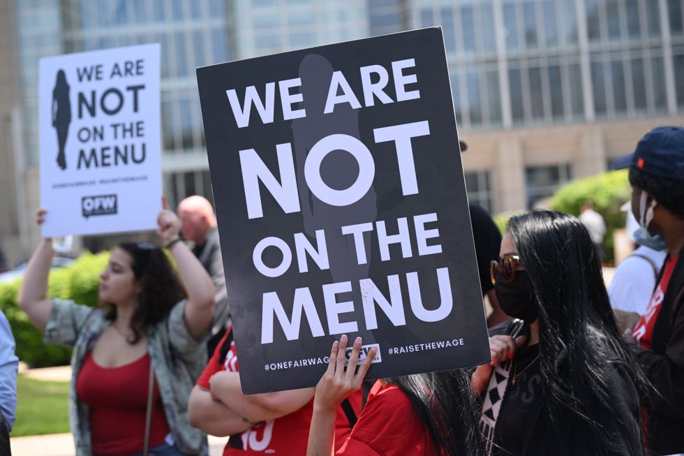 Protesters hold signs saying, "We are not on the menu."