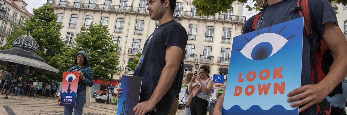 Protesters hold signs to demand an end to deep-sea mining