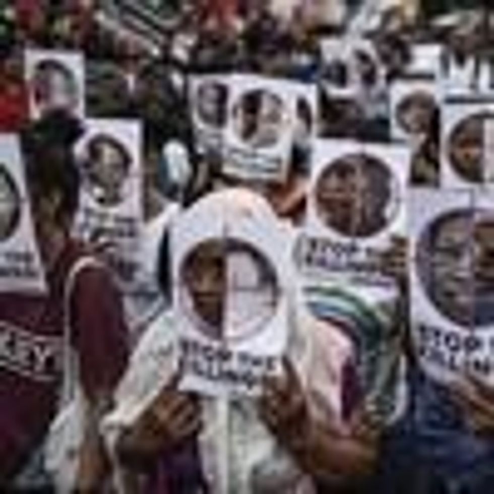 Protesters hold up pictures of victims of extrajudicial killings during Human Rights Day protests in Manila