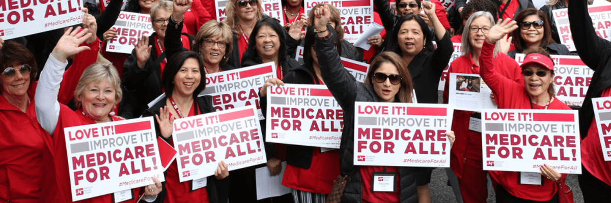 Protesters holding Medicare for All signs.