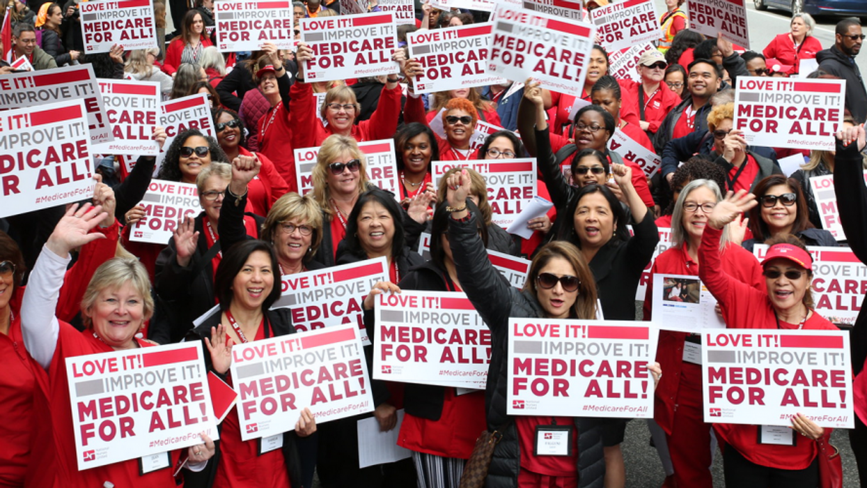 Protesters holding Medicare for All signs.