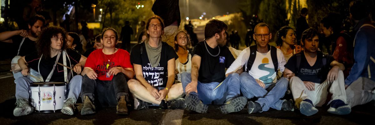 Protesters in Israel block road and link arms.