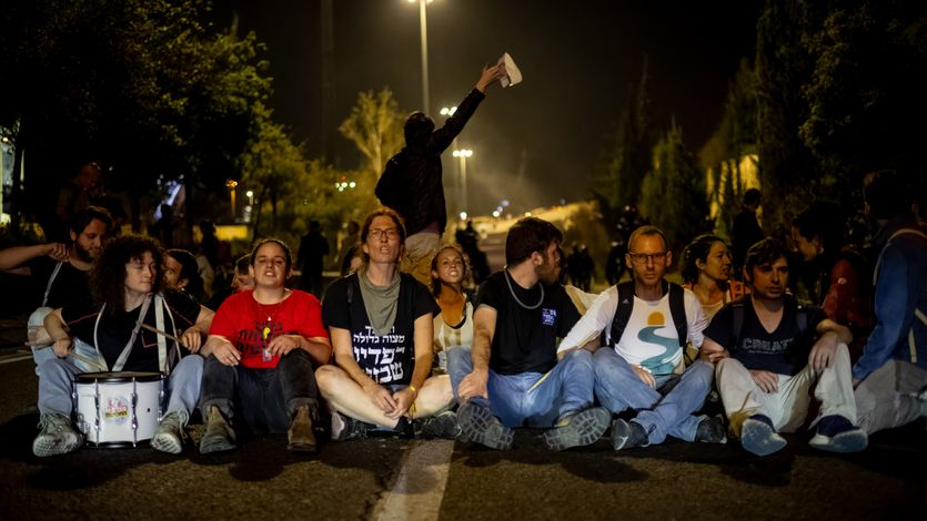 Protesters in Israel block road and link arms.