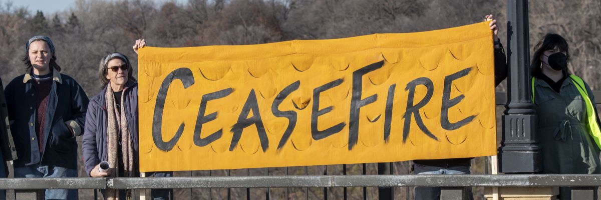 Protesters in Minnesota hold up a banner reading "Cease-fire."
