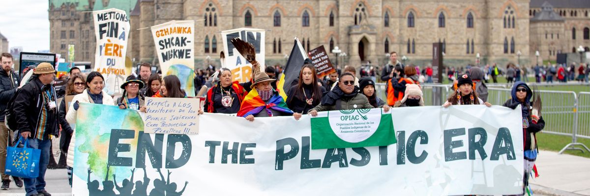 Protesters in Ottawa carry sign saying," End the Plastic Era."