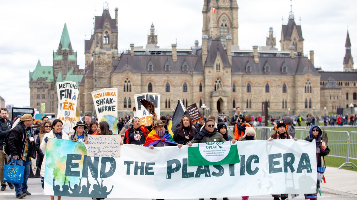 Protesters in Ottawa carry sign saying," End the Plastic Era."