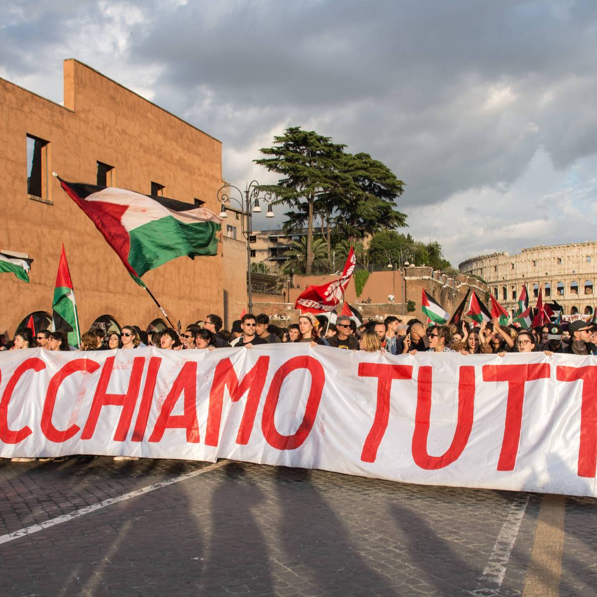 Protesters in Rome hold a banner reading "block everything" as they march near the Colisseum