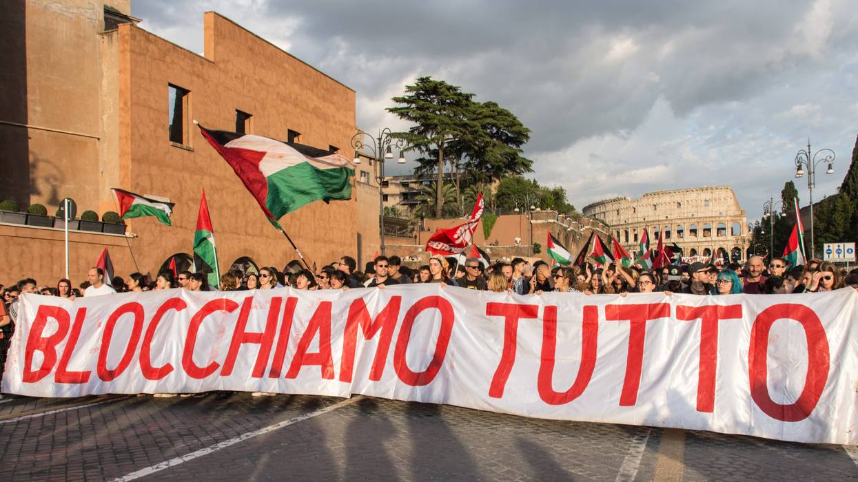 Protesters in Rome hold a banner reading "block everything" as they march near the Colisseum