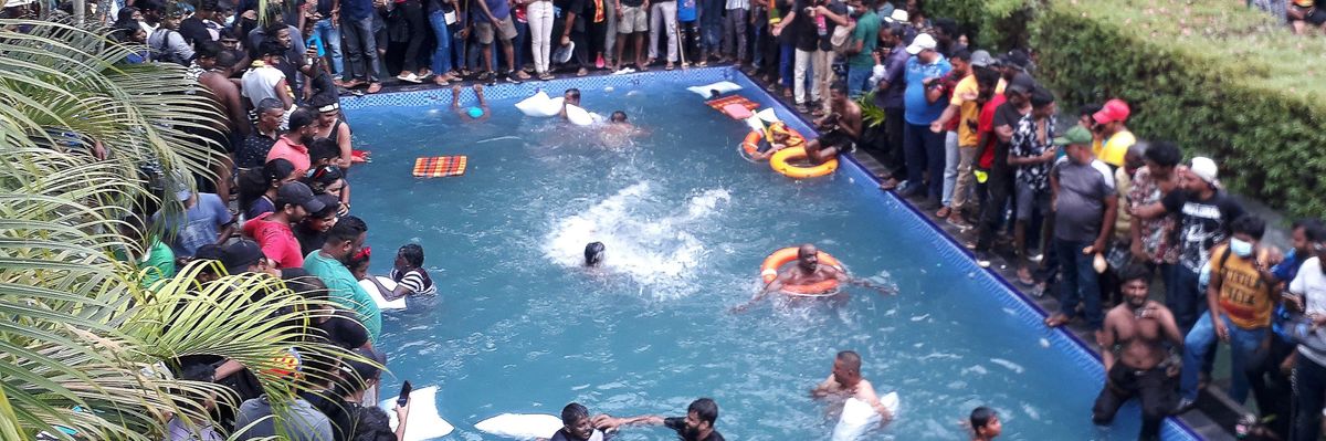 Protesters in Sri Lanka surround the pool, some of them swimming, after overrunning the presidential palace