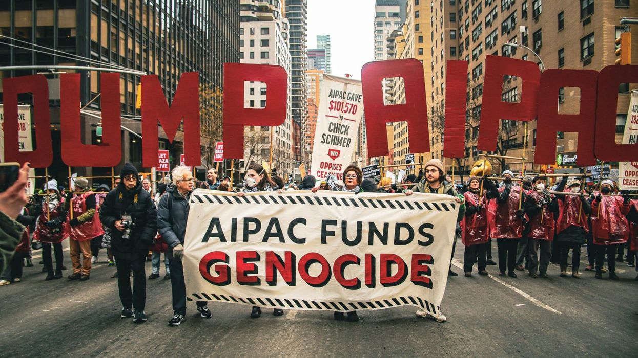 Protesters march with a banner reading, "AIPAC funds genocide."