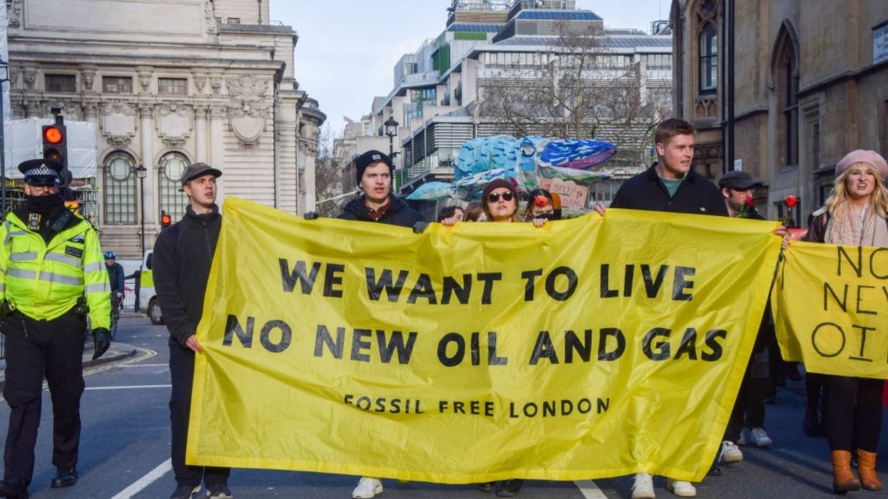 Protesters march with an anti-fossil fuel banner during the...
