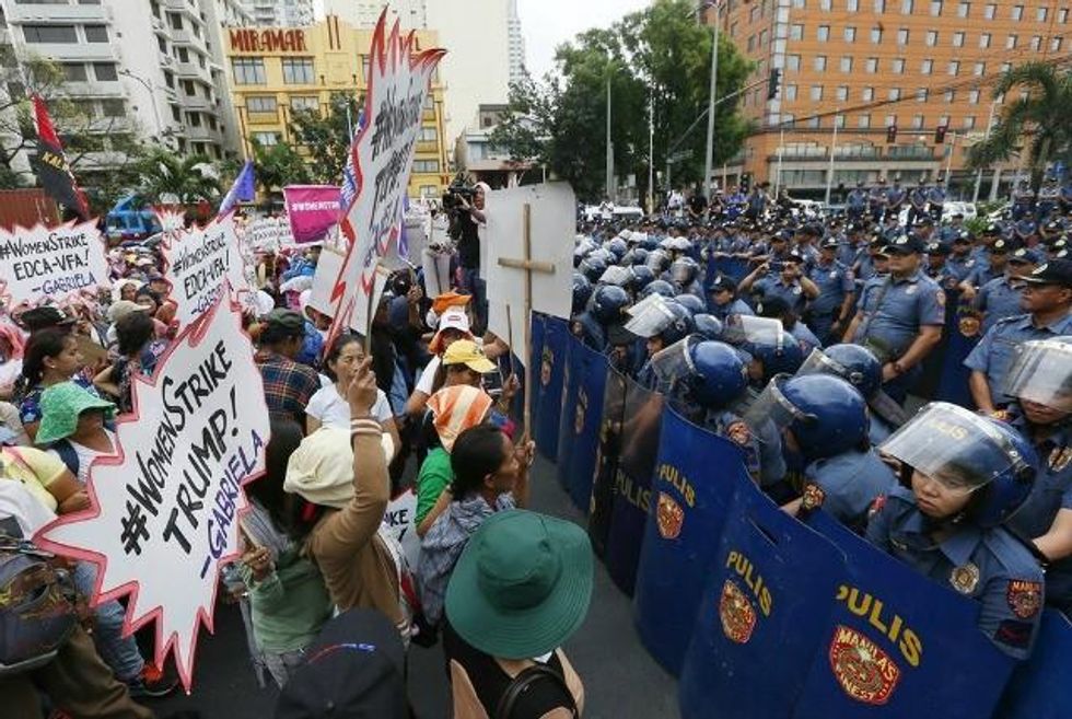 Protesters meet a line of riot police as they attempt to march to the U.S. embassy in Manila. (Photo: AP)